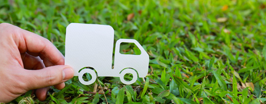 A paper truck cutour is moving through the grass